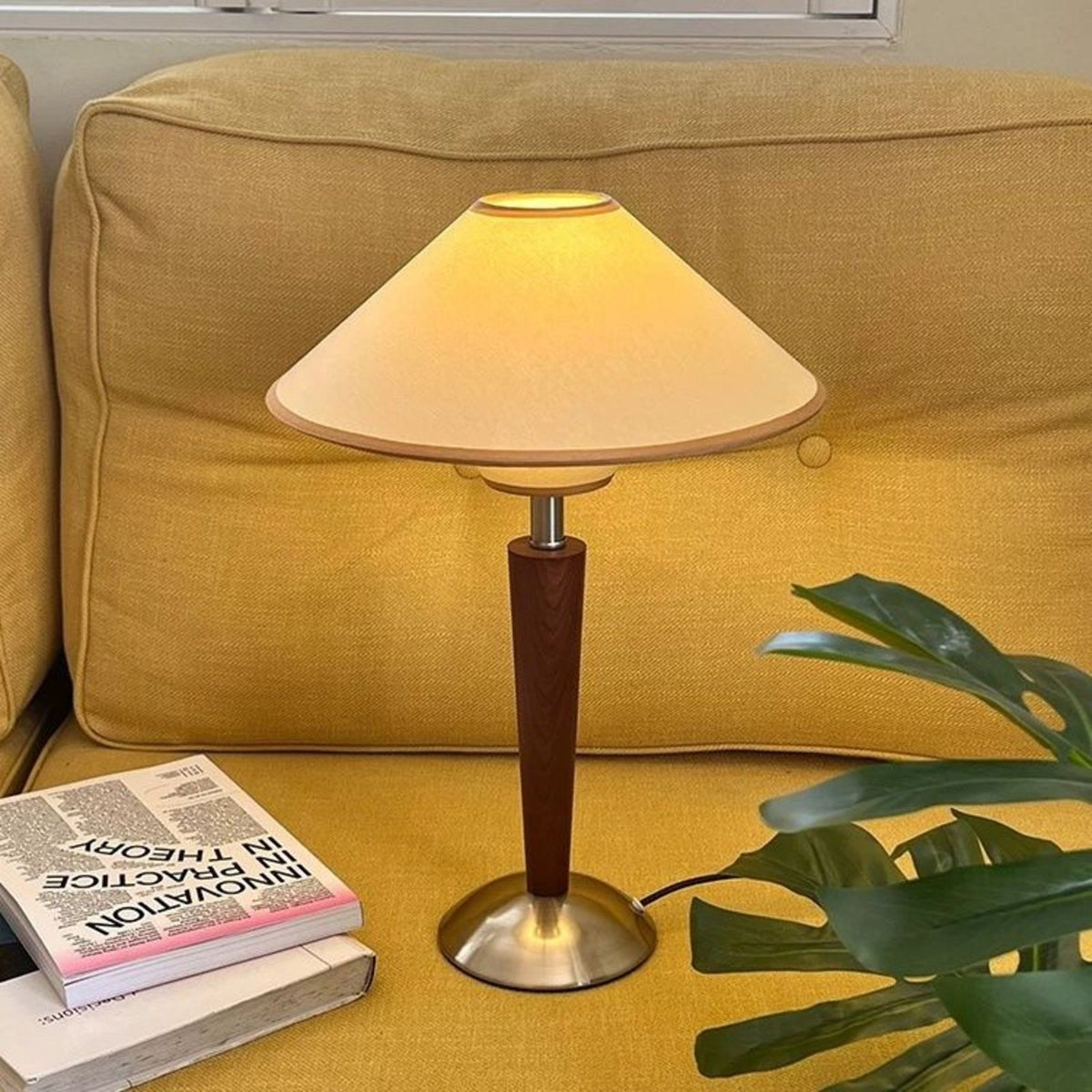Mori lamp with cream shade glowing on a sofa