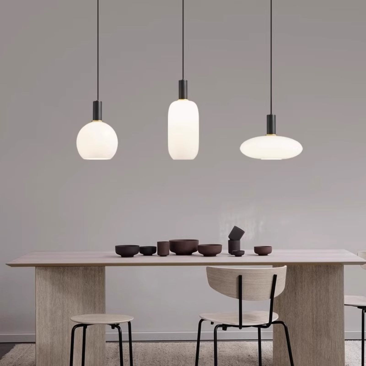 Selma opal glass pendant lights in round, tall and oval shapes above a dining table