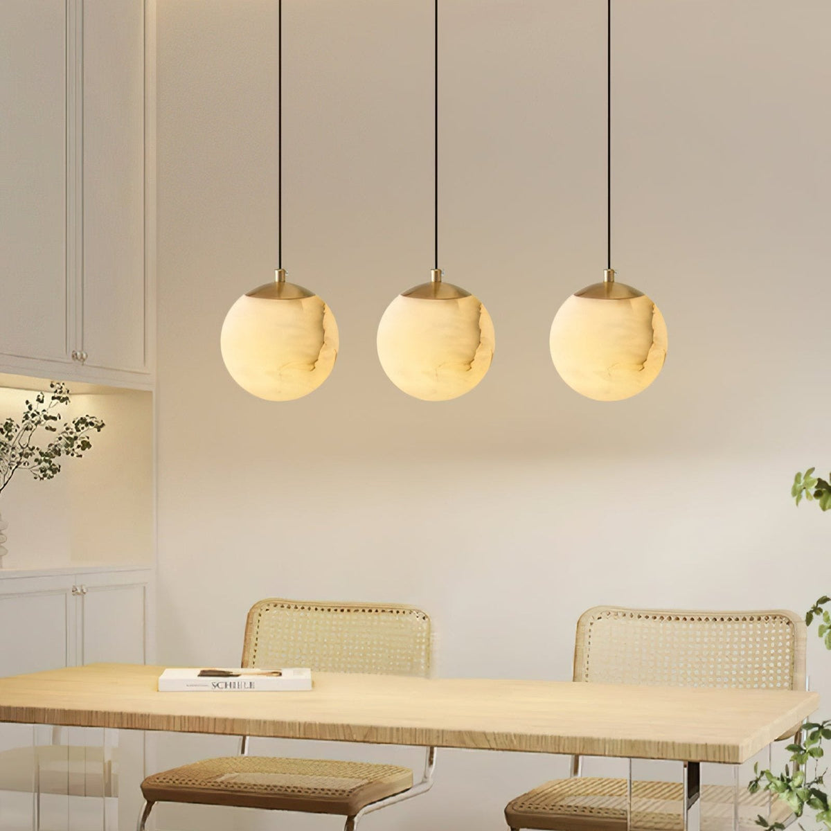 Three alabaster globe pendant lights above a dining table