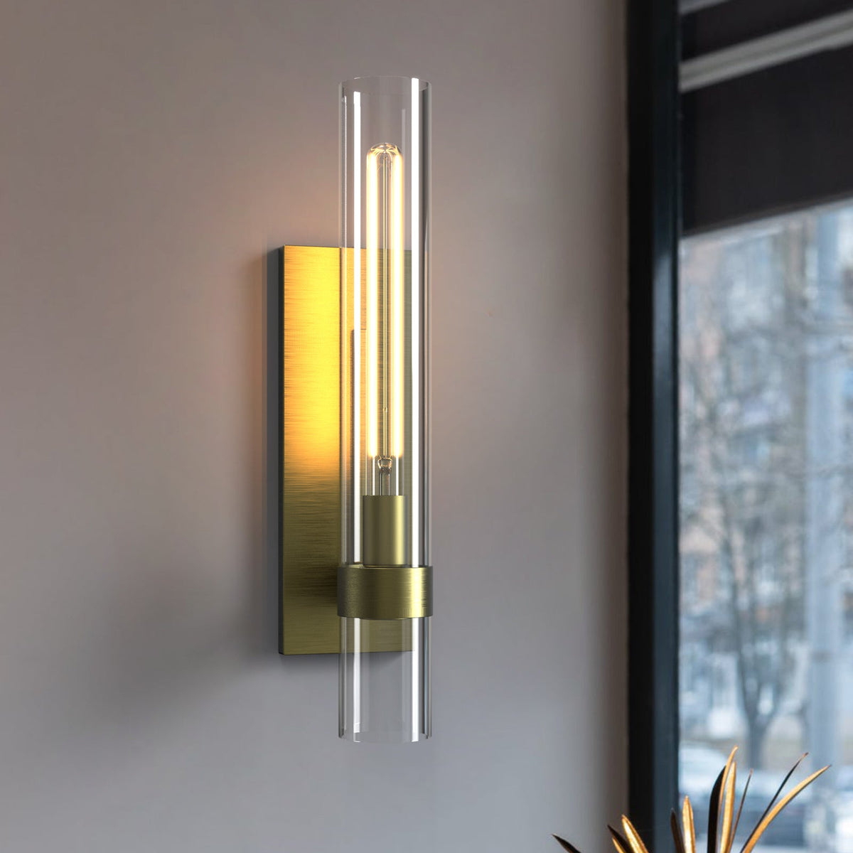 Brass glass tube wall light in a modern hallway