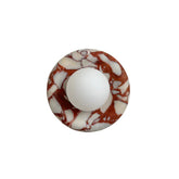 Marble-patterned circular object with a white center on a light gray background