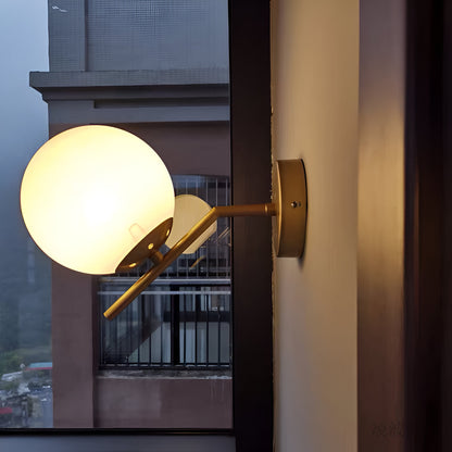 Lámpara de pared con pantalla de bola de vidrio blanco acabado en latón dorado