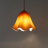 Amber glass skirt pendant light glowing