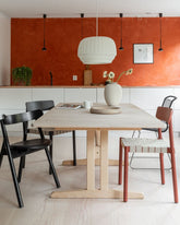 Wren pendant over a round dining table against a terracotta wall