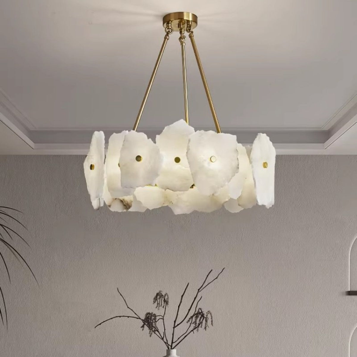 Isola alabaster chandelier above a vase of branches