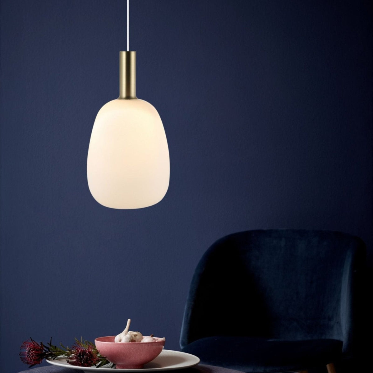 Selma tall opal glass pendant lit in a living room