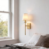 Shiori brass wall light beside a bed