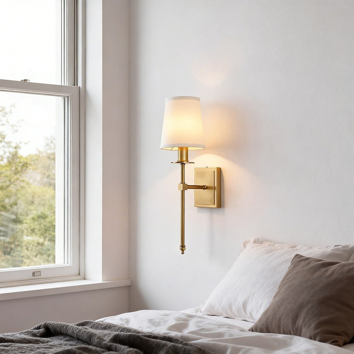 Shiori brass wall light beside a bed