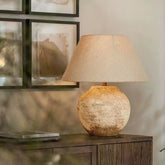Tsumugi wabi sabi lamp on a dark wood shelf by a window