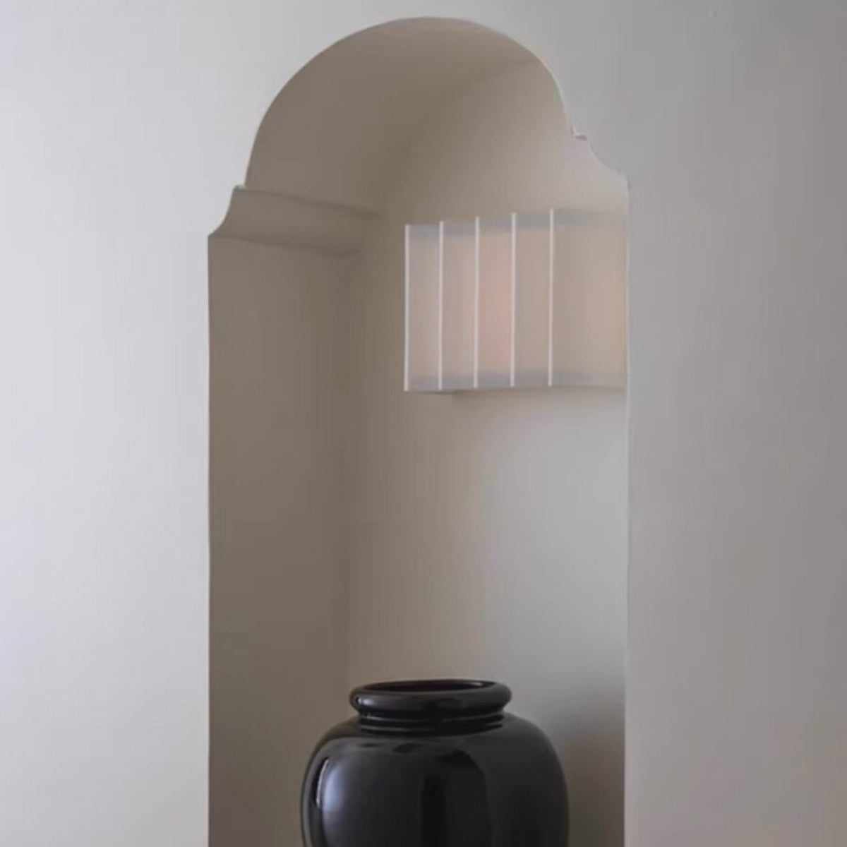 Wave pleated wall lamp in an arched wall niche